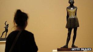 A woman looks at Degas' La Petite Danseuse de Quatorze Ans