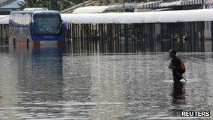 Man wading through flooded station in Bangkok