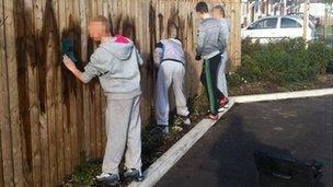 Teenagers cleaning graffiti. Photo: Cleveland Police