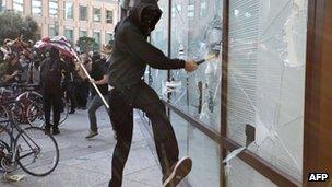 A masked protester smashes a window at a bank in Oakland. Photo: 2 November 2011