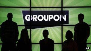 Groupon staff in front of logo