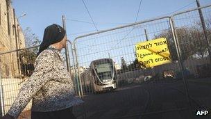An ultra orthodox Jewish woman stands by an unfinished section of the railway in Jerusalem, November 16, 2010