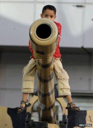 Boy perched on gun barrel