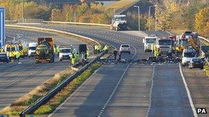 Police search through the debris on the M5 motorway in Somerset