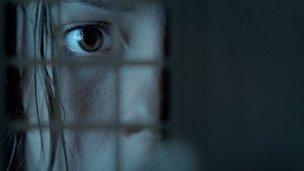 Rebecca Hall peers through a doll's house window in The Awakening