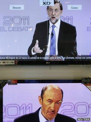 TV screens in Malaga show Alfredo Perez Rubalcaba (bottom) listening to Mariano Rajoy (top) during the televised debate in Spain on 7 November 2011