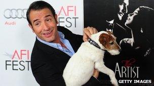 Actor Jean Dujardin poses with Uggie the dog on arrival for the Gala screening of The Artist