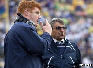 Penn State head coach Joe Paterno (R) talks with assistant coach Mike McQueary (L)