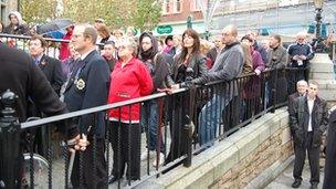 People gathered on a wheelchair ramp