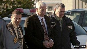 Jerry Sandusky (C) is led away by police in Harrisburg, Pennsylvania, on 5 November 2011