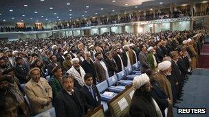 Members of the loya jirga stand up as the national anthem plays in Kabul November 16, 2011