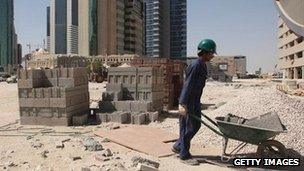 A construction worker pushing a wheelbarrow in the financial district of Doha, Qatar (file photo)