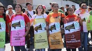 Protesters wearing banners saying "Young people against violence"