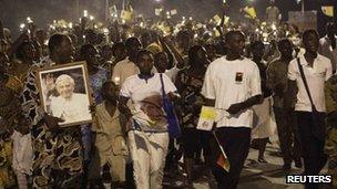 Worshippers carry oil lanterns and dance during a night time procession through the streets of Benin"s main city of Cotonou, 17 November 2011