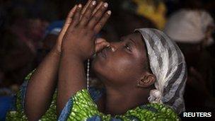 A woman prays at morning Mass in Benin's Notre Dame cathedral, 18 November 2011