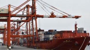 Containers are loaded onto a cargo ship at Tokyo port