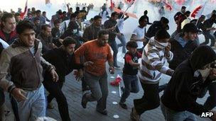 Protesters run from tear gas in the village of Sanabis, near Manama, Bahrain, on 14 February 2011