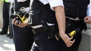 A police officer with Taser guns