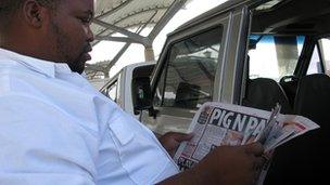 A South African minibus taxi driver reading a newspaper