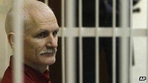 Ales Belyatski sits in a cage in court in Minsk, 24 November 2011