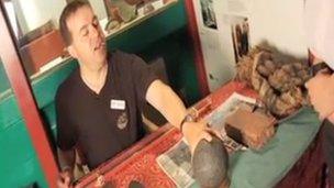 Neil Clements shows a museum visitor a 500-year-old cannon ball.