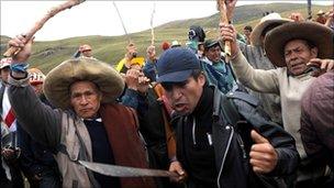 Peruvian protesters brandishing sticks and machetes