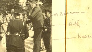 Hitler signing a book among a crowd