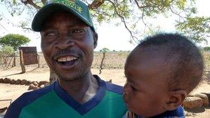 Shadrack Rwafa holding a baby