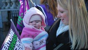 Mother with baby waving placard