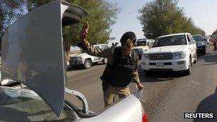 A Saudi policeman checks cars in Saudi Arabia's eastern Gulf coast town of Qatif 25 November 2011