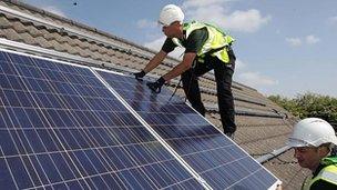 Men installing solar panels on a roof