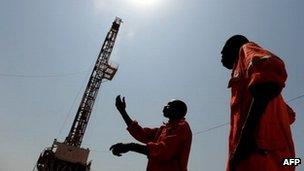 Two workers born in the oil reach Southern Sudan state of Unity, stand on the drilling site number 102 in the Unity oil field in Southern Sudan on November 11, 2010.