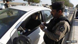 A Saudi policeman checks a driver in Saudi Arabia's eastern Gulf coast town of Qatif 25 November 2011