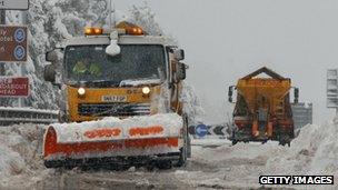 Snow ploughs clear deep snow on a main road in Scotland.