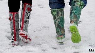 People in colourful wellies walking in the snow
