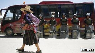 A woman walks past police in Cajamarca during a strike against the Conga gold mine project - 25 November 2011