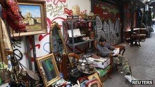 A shop owner sits on an old armchair at his open air antique shop in central Athens October 2011.