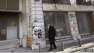 A man walks past shops, which have been closed since last year, in central Athens October 27, 2011.