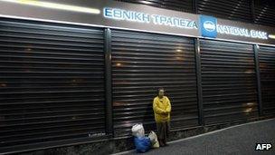 A woman stands in front of a national bank during a protest at the Athens' Syntagma Square on 4 November 2011 in Athens