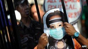 A protester wearing a mask carrying the image of former Philippine president Gloria Arroyo in Manila on November 29