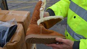 A UKBA officer with one of the fake Ugg boots seized at Southampton Docks