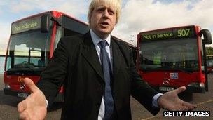 London Mayor Boris Johnson in front of two bendy buses