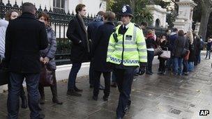 Expatriate Russians queue to vote in Russian Parliamentary elections watched by a British policeman outside their Embassy in London's Notting Hill on Sunday Dec 4