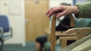 Elderly lady with walking stick in waiting room