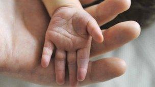 Baby and adult hand