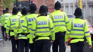 Police officers in high visibility jackets walking away from the camera