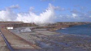 Waves crash over the Alderney breakwater