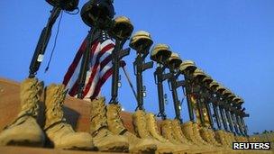 A row of US Army helmets perched on M-16 rifles at a memorial at Al-Asad air base in November 2003