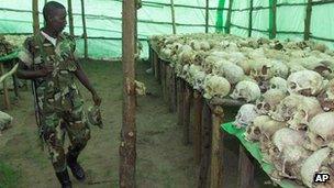 Rwandan soldier looks at the human skulls belonging to victims at the genocide memorial in Bisesero, Rwanda, November 2nd 1999