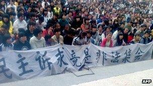 Undated handout picture taken by a villager shows Wukan residents carrying a banner saying "democratic appeal can hardly be illegal rally"